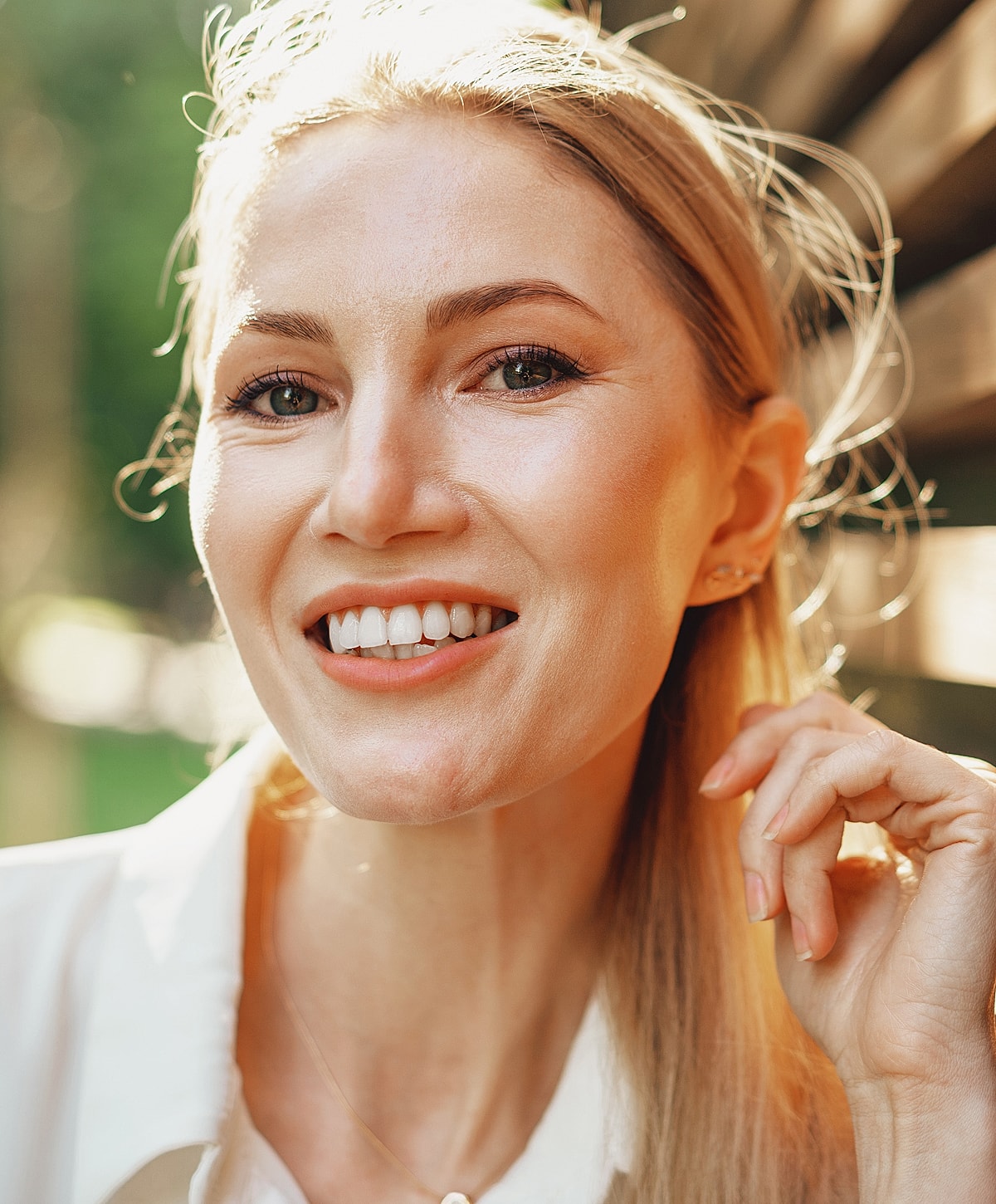Smiling woman in natural light against background.