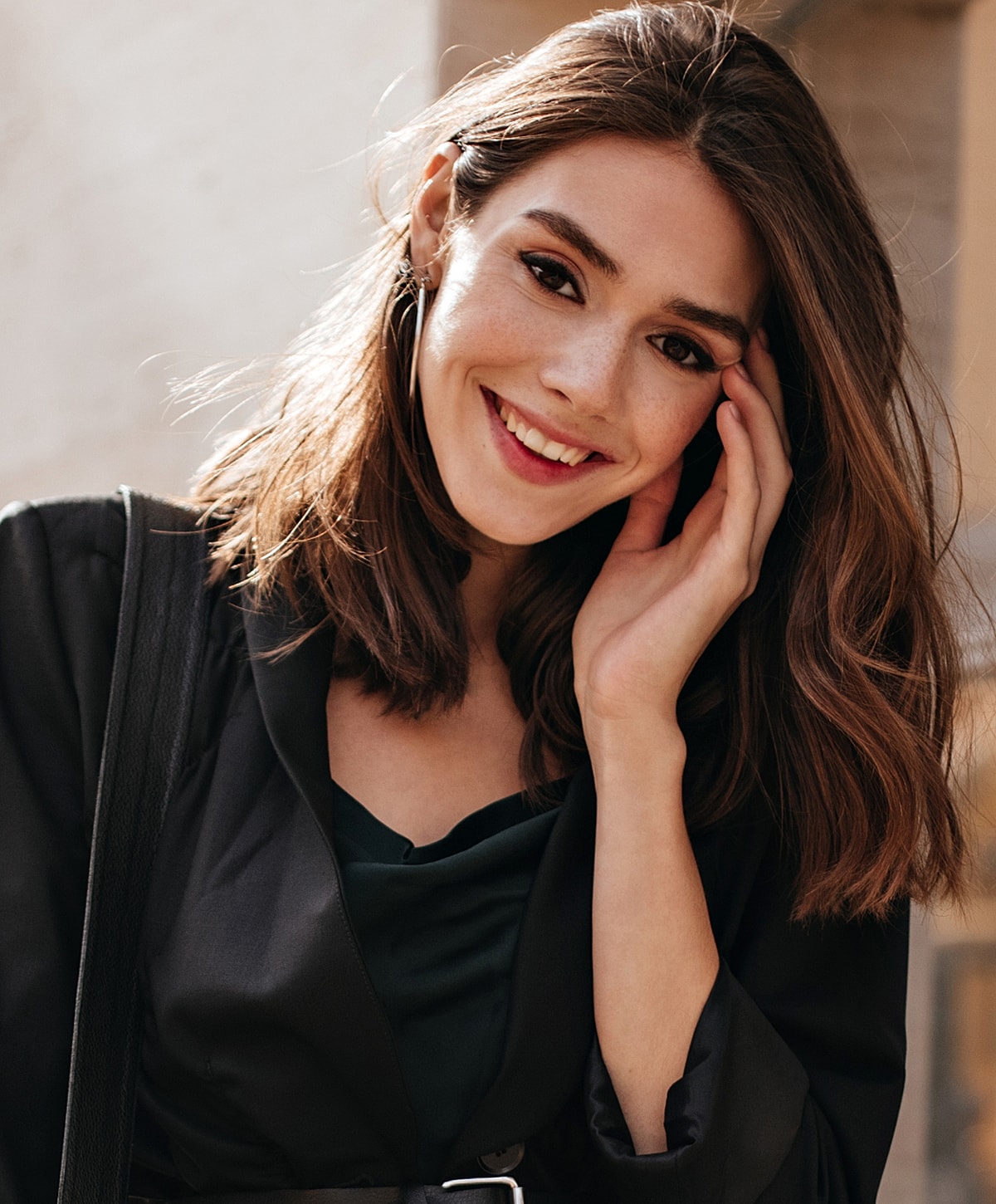 Smiling woman with long hair, wearing a black outfit.