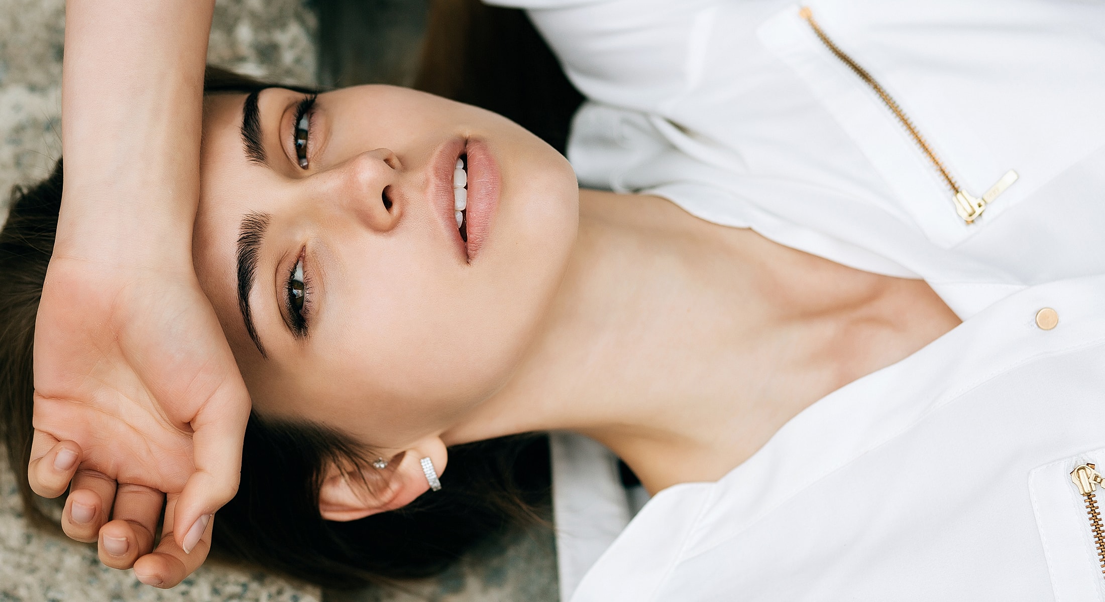 Woman in white shirt resting on her arm.