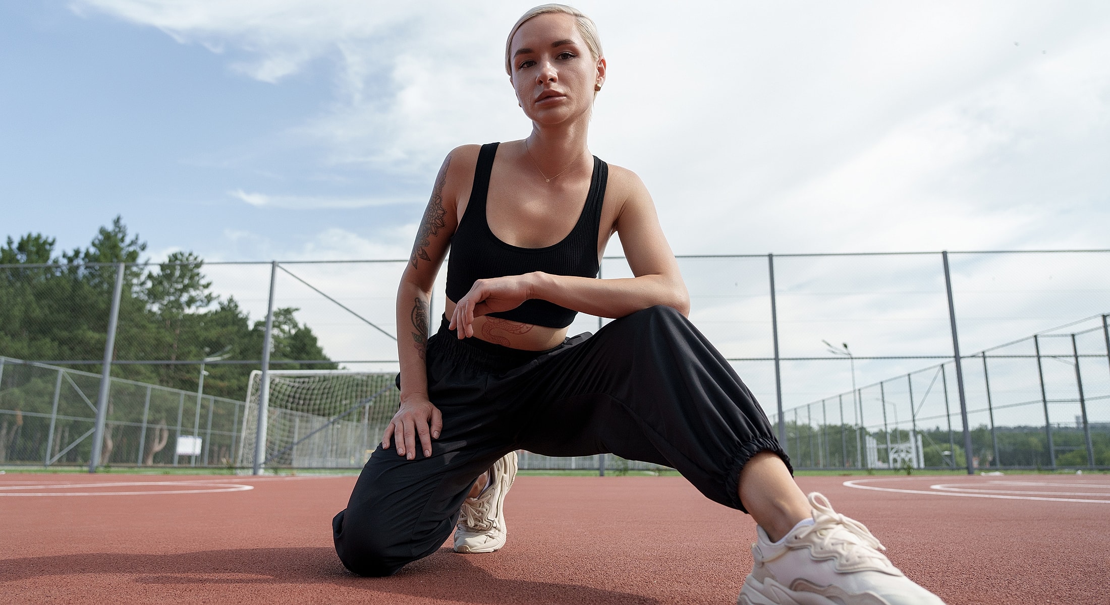 Athletic person posing on outdoor court.